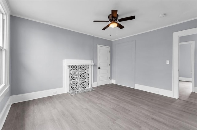 unfurnished room with baseboards, wood finished floors, a ceiling fan, and crown molding