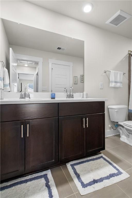 bathroom featuring tile patterned flooring, vanity, and toilet