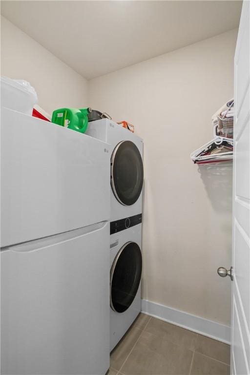 laundry area with tile patterned flooring and stacked washing maching and dryer