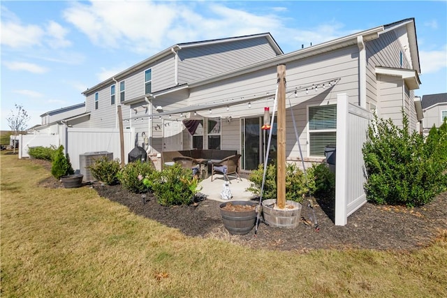 back of property featuring a lawn, a patio area, and central AC