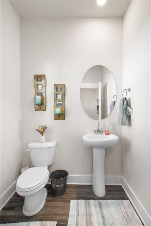 bathroom featuring hardwood / wood-style flooring and toilet