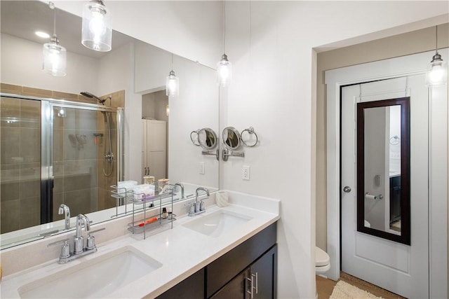 bathroom with vanity, toilet, and a shower with door