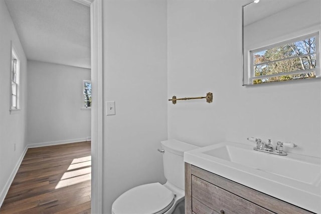 bathroom with hardwood / wood-style floors, vanity, and toilet