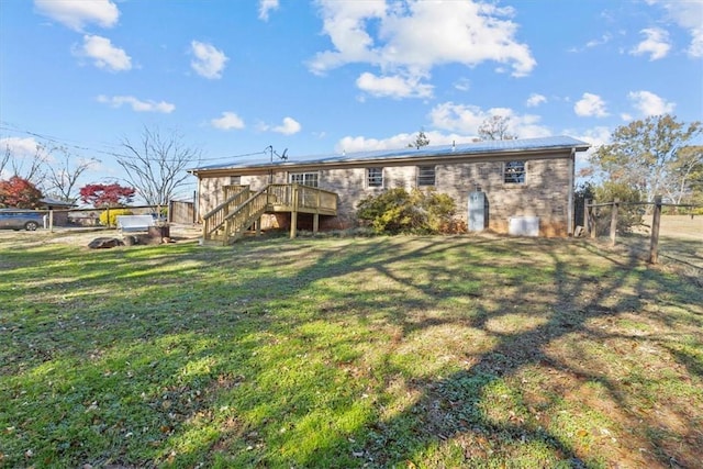 rear view of house with a lawn and a deck