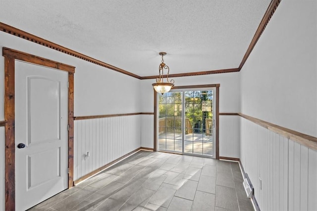 unfurnished room with a textured ceiling and ornamental molding