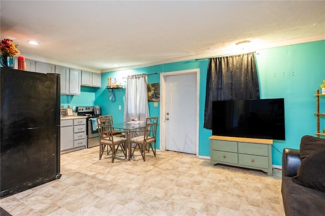 kitchen with black refrigerator and stainless steel range with electric stovetop