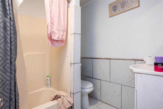 full bathroom with vanity, tile patterned flooring, toilet, tile walls, and shower / tub combo