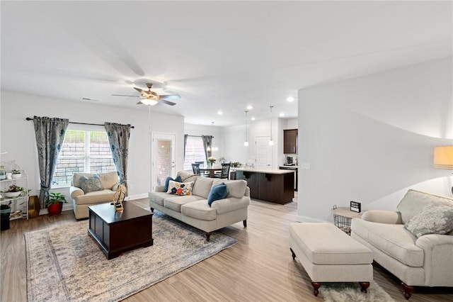 living room featuring light hardwood / wood-style floors and ceiling fan