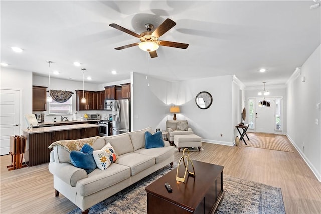 living room featuring ceiling fan, light hardwood / wood-style flooring, and ornamental molding