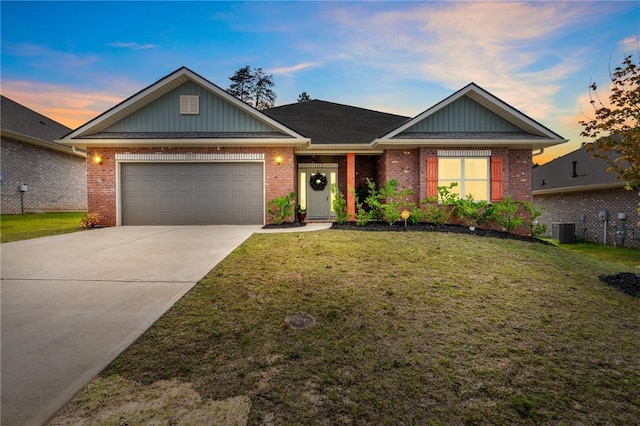 view of front of house featuring a lawn, central air condition unit, and a garage