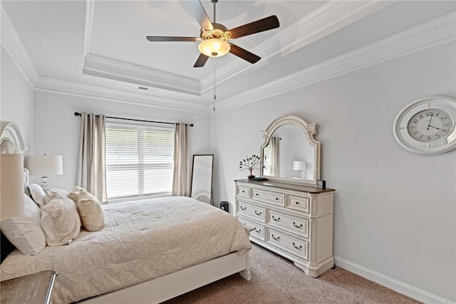 carpeted bedroom with ceiling fan, a raised ceiling, and ornamental molding