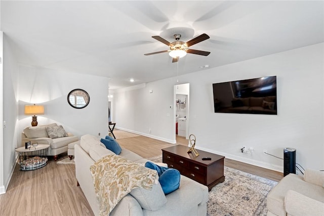 living room featuring light hardwood / wood-style floors and ceiling fan