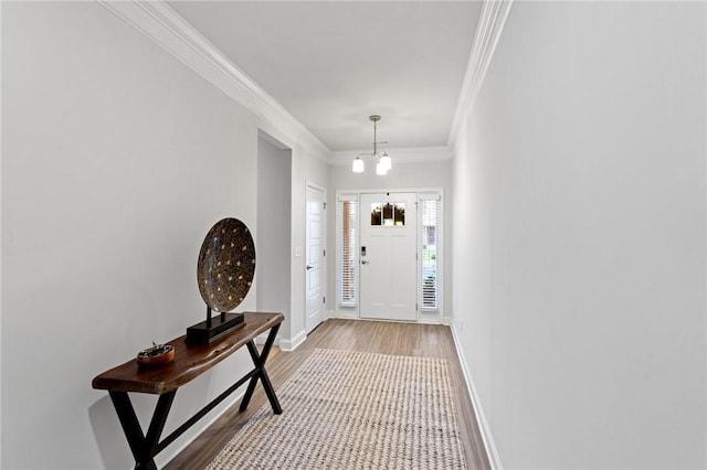 foyer featuring a chandelier, hardwood / wood-style floors, and ornamental molding