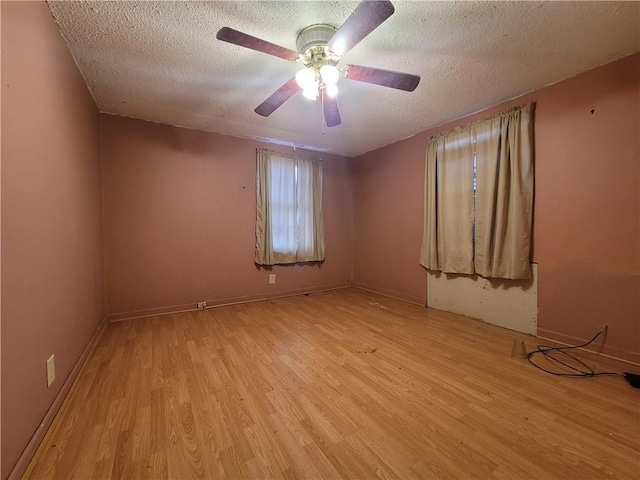 empty room featuring ceiling fan, light hardwood / wood-style floors, and a textured ceiling