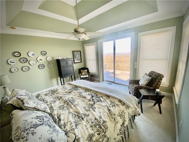 bedroom with access to outside, a raised ceiling, ceiling fan, and carpet