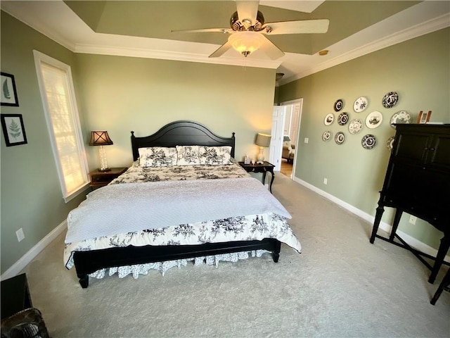 carpeted bedroom featuring a tray ceiling, ceiling fan, and ornamental molding