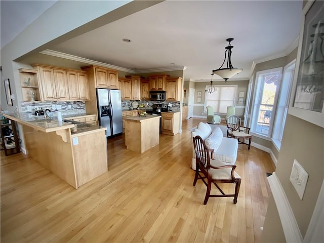 kitchen with kitchen peninsula, appliances with stainless steel finishes, pendant lighting, a notable chandelier, and light hardwood / wood-style floors