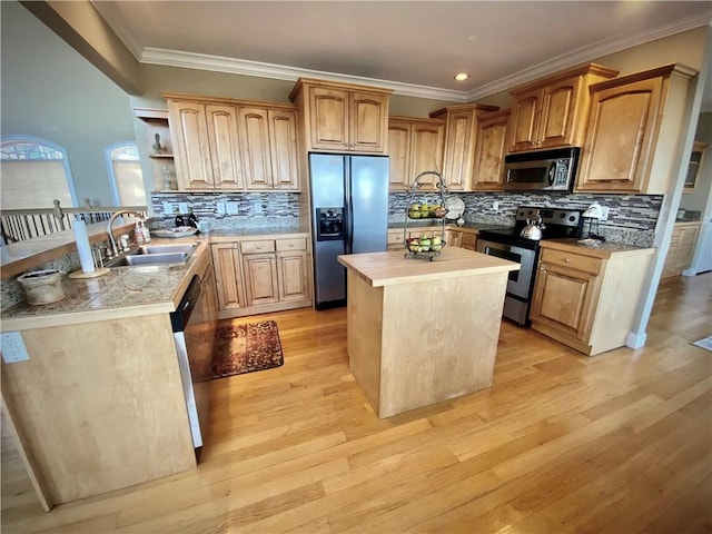 kitchen with a center island with sink, light hardwood / wood-style floors, sink, and appliances with stainless steel finishes