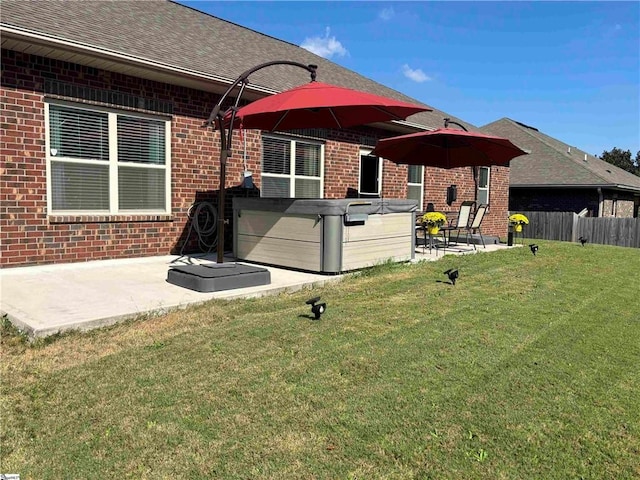 back of house with a patio, a lawn, and a hot tub