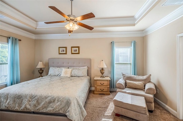 bedroom with ceiling fan, light colored carpet, ornamental molding, and a tray ceiling