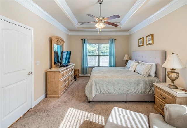 carpeted bedroom with ceiling fan, a tray ceiling, and crown molding