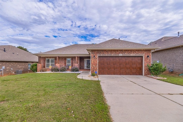 single story home featuring central air condition unit, a front yard, and a garage