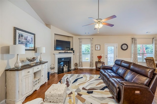 living room featuring ceiling fan, dark wood-type flooring, and vaulted ceiling