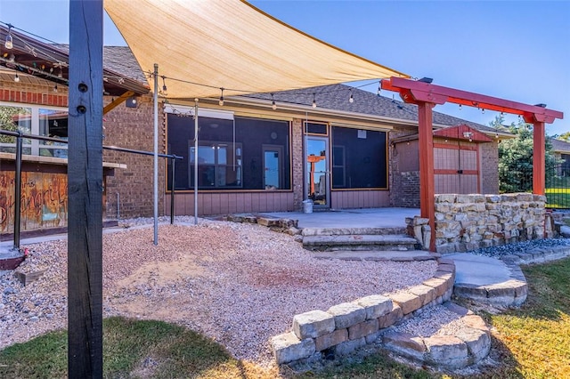 exterior space with a sunroom, a storage unit, and a patio area