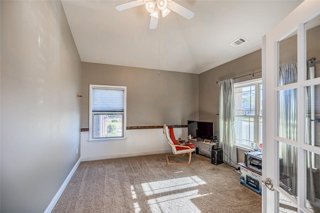 living area featuring carpet flooring, vaulted ceiling, and plenty of natural light