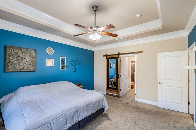 bedroom featuring light colored carpet, a tray ceiling, ceiling fan, crown molding, and a barn door