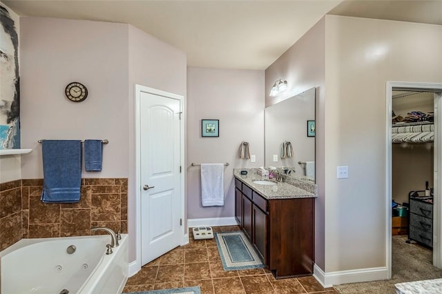 bathroom featuring tile patterned flooring, vanity, and a tub