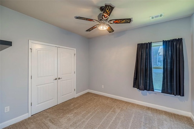 unfurnished bedroom featuring ceiling fan, a closet, and light carpet