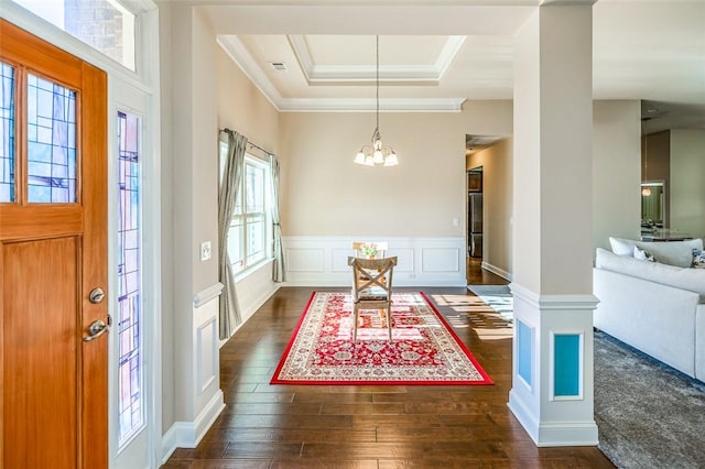 entrance foyer with a notable chandelier, crown molding, dark wood-type flooring, and a tray ceiling