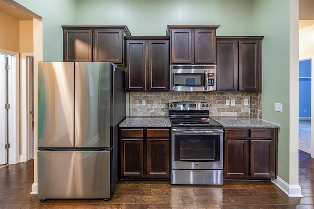 kitchen featuring backsplash, dark brown cabinets, dark hardwood / wood-style flooring, and stainless steel appliances