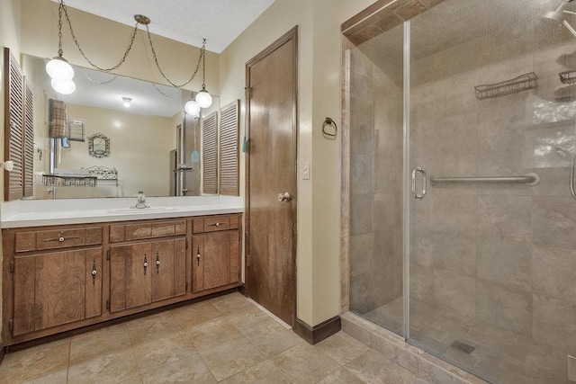 bathroom featuring vanity, an enclosed shower, and a textured ceiling