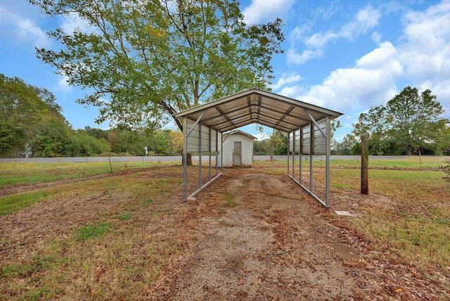 exterior space featuring a carport, a storage unit, and a rural view