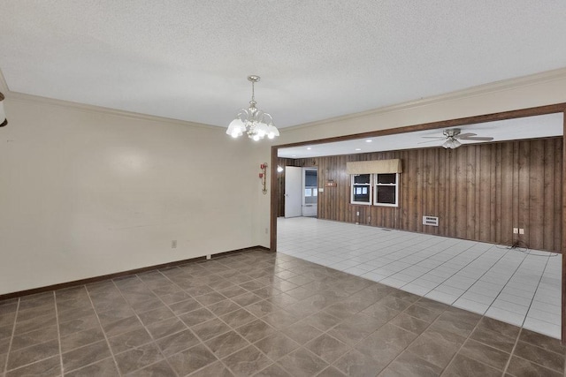 tiled spare room featuring a textured ceiling, ceiling fan with notable chandelier, crown molding, and wooden walls