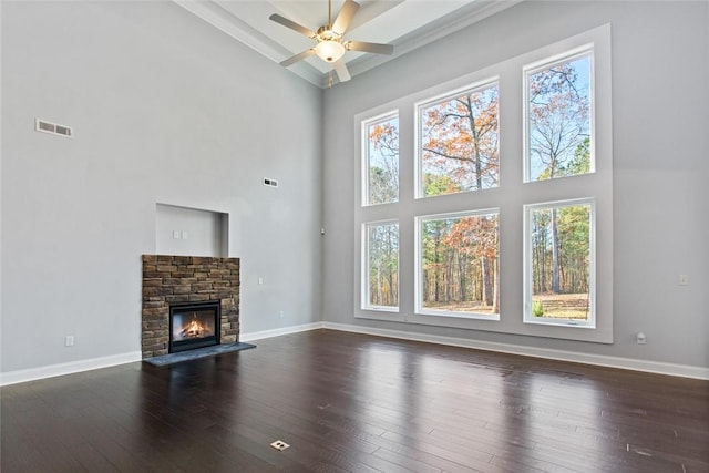 unfurnished living room featuring dark hardwood / wood-style flooring, a towering ceiling, and plenty of natural light