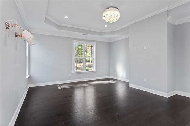 spare room with a chandelier, crown molding, a tray ceiling, and dark wood-type flooring