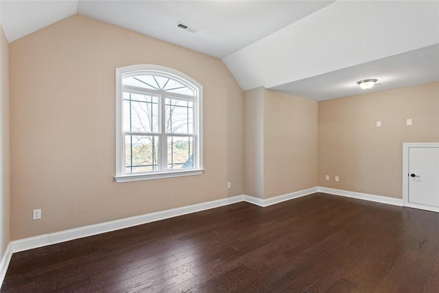 empty room with hardwood / wood-style floors and lofted ceiling