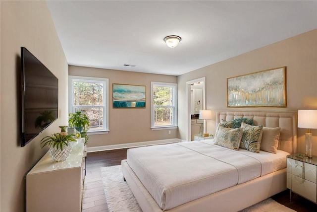 bedroom with wood-type flooring and multiple windows