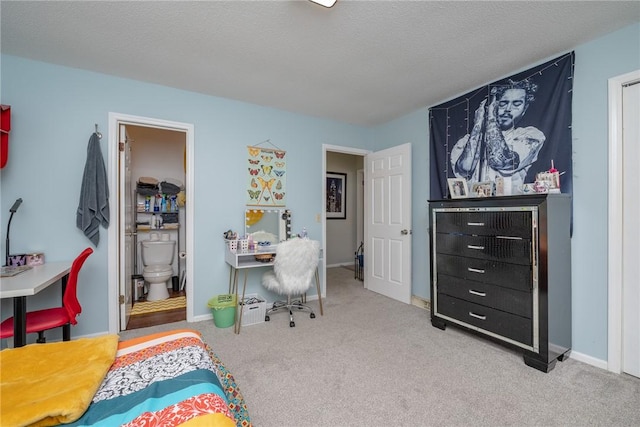 bedroom with carpet flooring, ensuite bath, and a textured ceiling