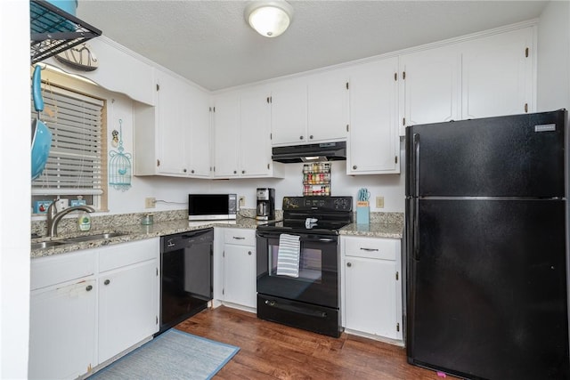 kitchen with light stone counters, dark wood-type flooring, sink, black appliances, and white cabinets