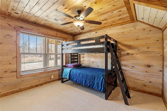 bedroom featuring ceiling fan, wood walls, wooden ceiling, and carpet floors