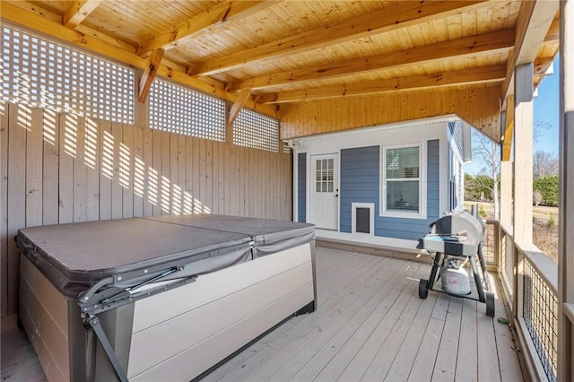 wooden deck with a hot tub and a grill