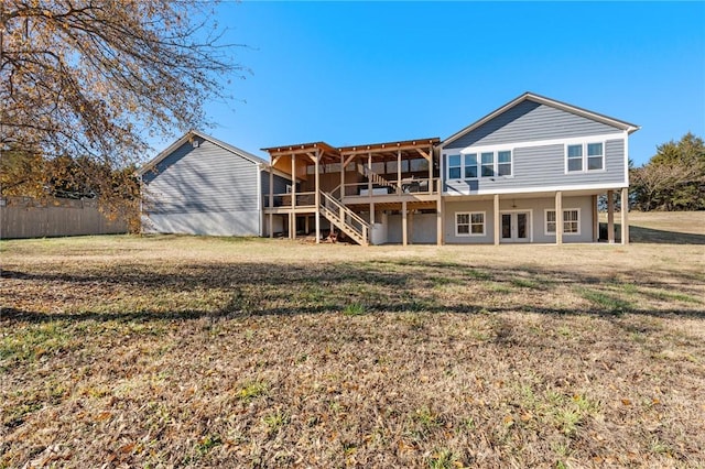 rear view of house with a lawn, a wooden deck, and french doors