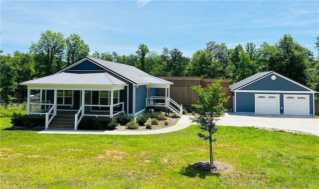 view of front of home with a garage, covered porch, an outbuilding, and a front yard