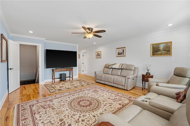 living room featuring hardwood / wood-style flooring, ceiling fan, and ornamental molding