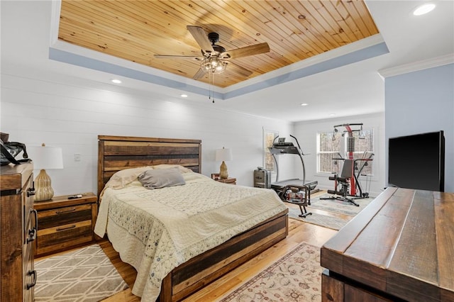 bedroom with wood walls, a raised ceiling, ceiling fan, light wood-type flooring, and wood ceiling