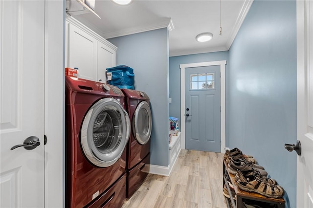 laundry area featuring washing machine and clothes dryer, light hardwood / wood-style flooring, cabinets, and ornamental molding